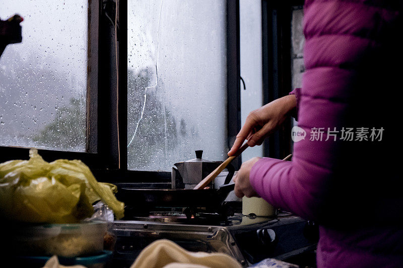 女人在山里的避难所准备了一些温暖的食物