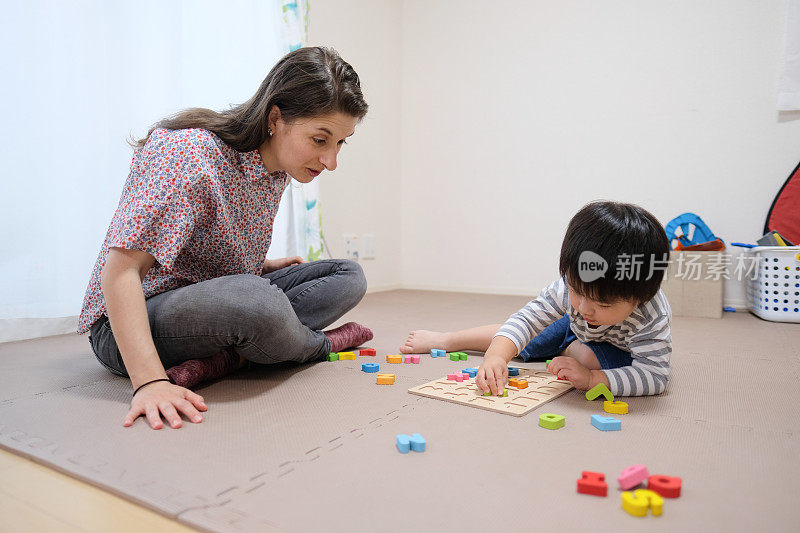 白种妇女教英文给亚洲幼童字母块