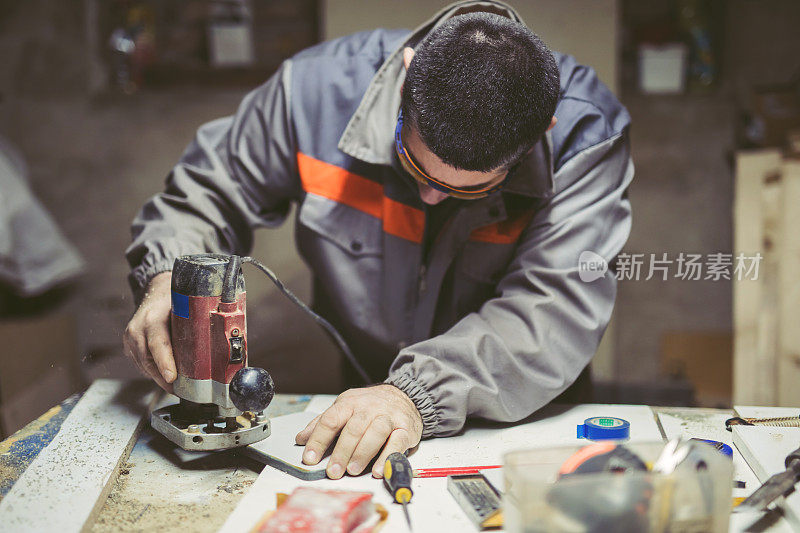 中年男子工作与木材路由器