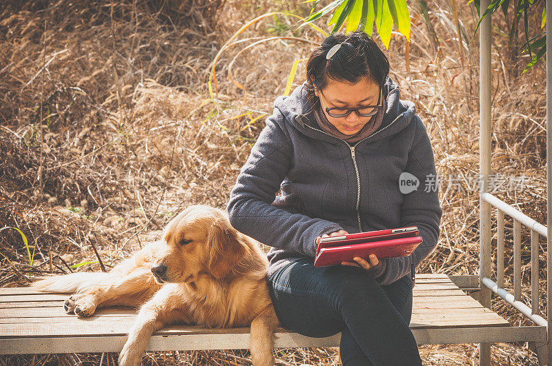 一个亚洲女人和一只金毛猎犬