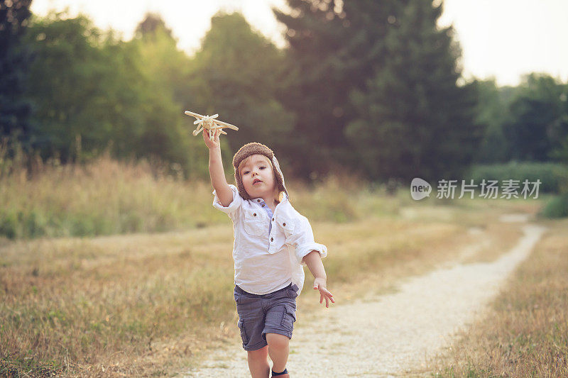 小男孩在公园里玩木制飞机
