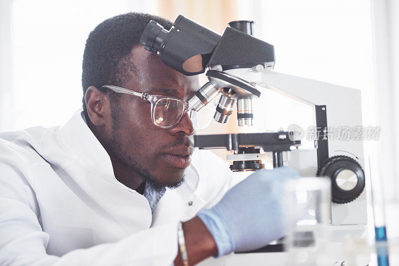 这位科学家在实验室里用显微镜进行实验和计算公式。