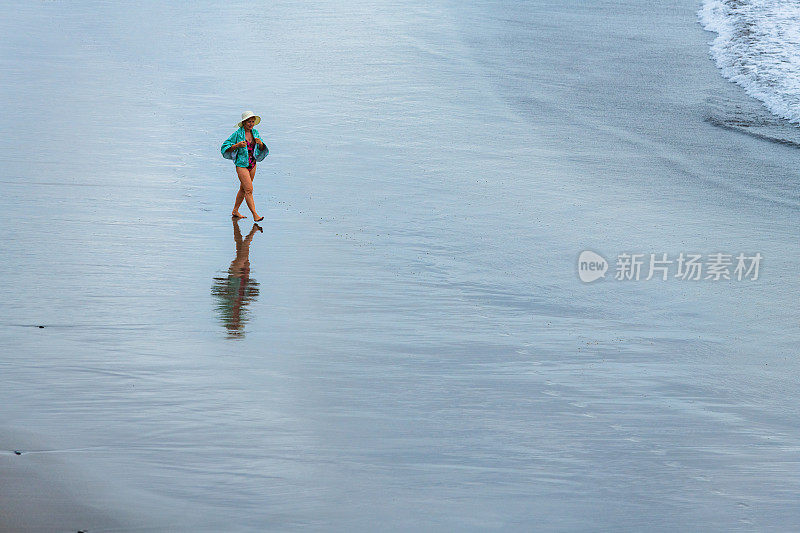 西班牙特内里费岛，一个成熟的女人在沙滩上散步