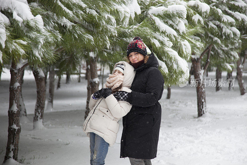 妈妈和女儿在雪中玩耍