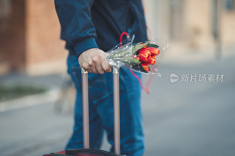 提着行李箱走在城市里的商人。