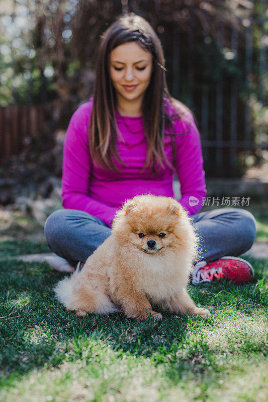 微笑的年轻女子和她的博美犬