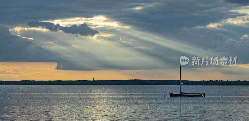 阳光照在湖面上，船的轮廓和蓝色的云景