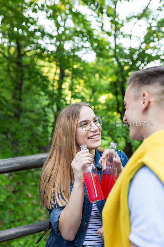 一对年轻夫妇在森林里享受着他们的爱情，面带微笑