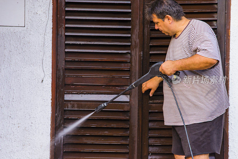 男人用喷水器清洁房屋