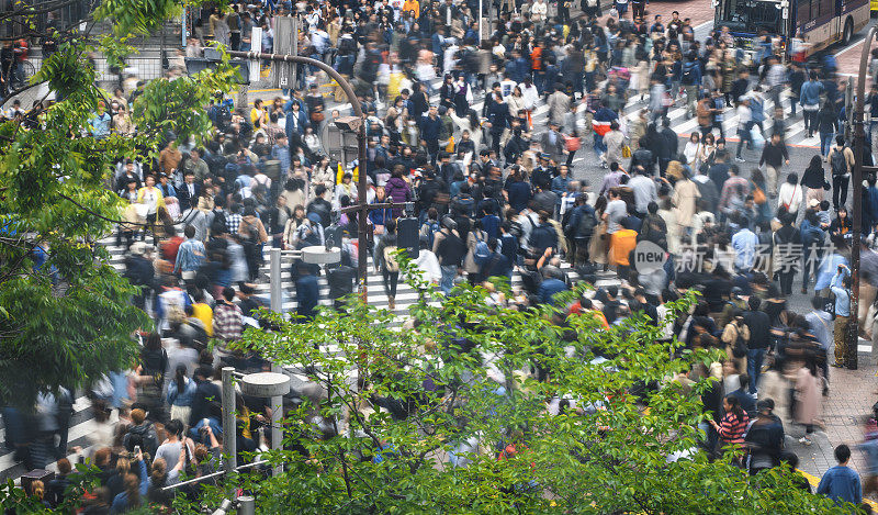 人们正在穿过东京著名的涩谷十字路口