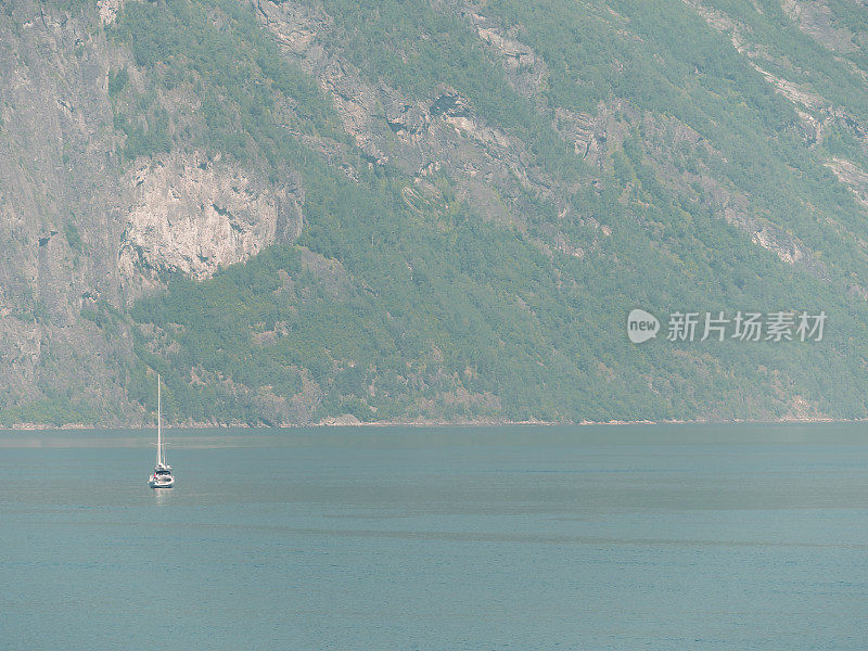 空中飞过盖兰格峡湾宁静的水面，背景是群山