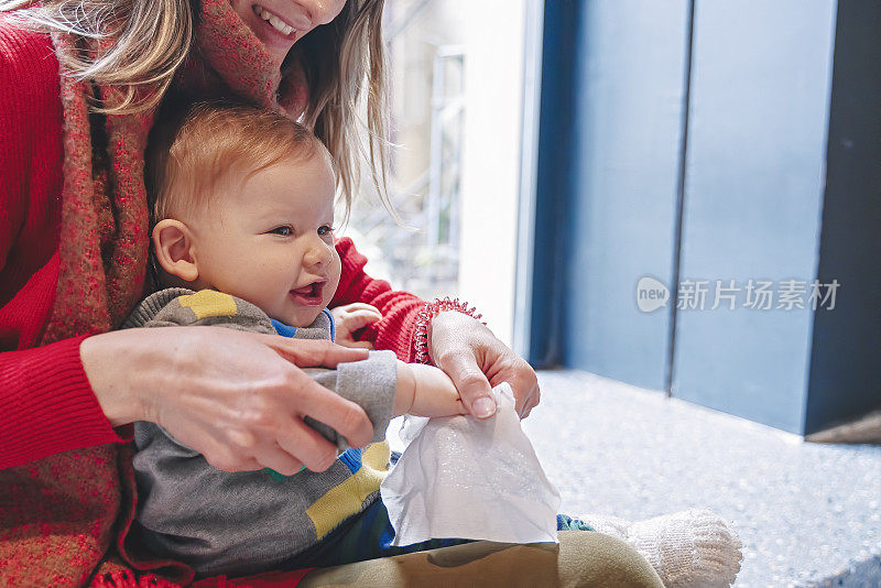 妈妈用我们的纸巾擦她孩子的手