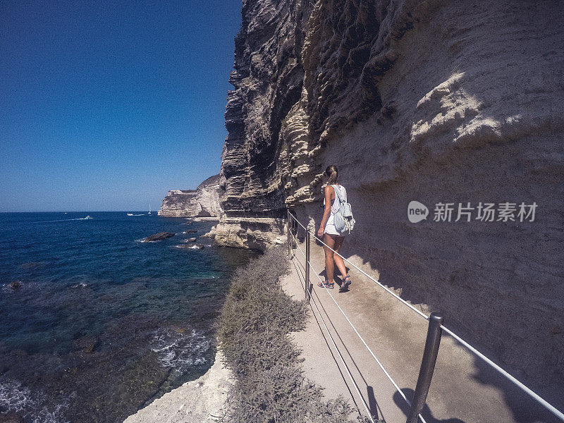 一个成年女子在悬崖边的小路上行走