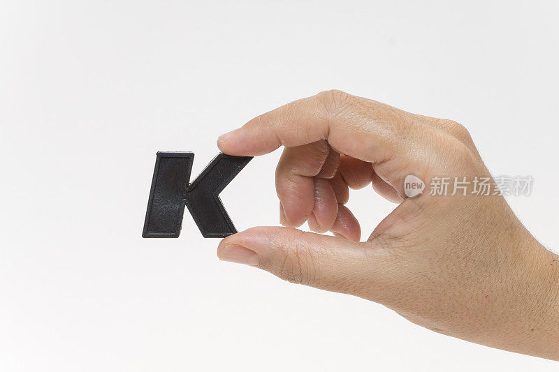 女性手握塑料字母K
