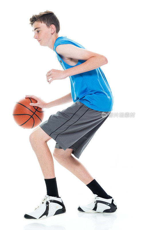 白人少年篮球运动员在白色的背景和抱篮球和使用运动球