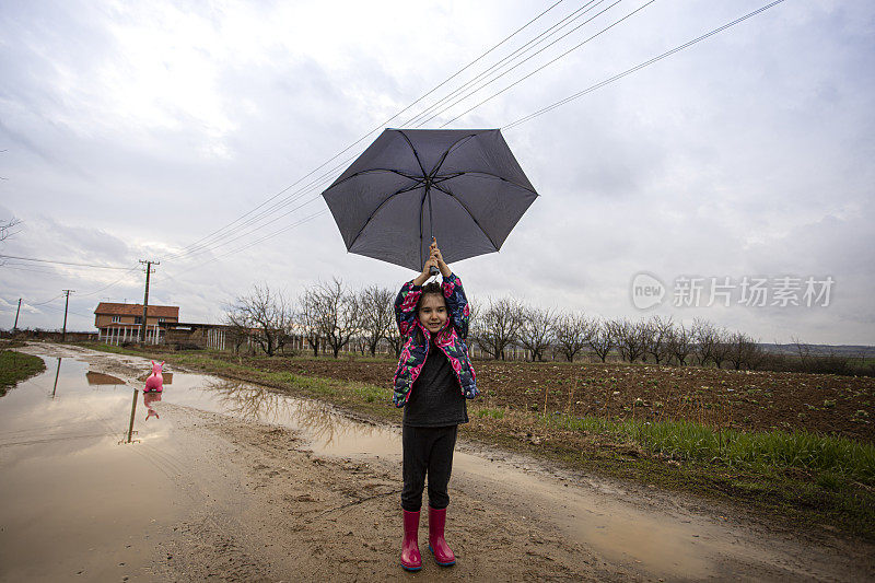 一个小女孩在一个雨天拿着一把伞