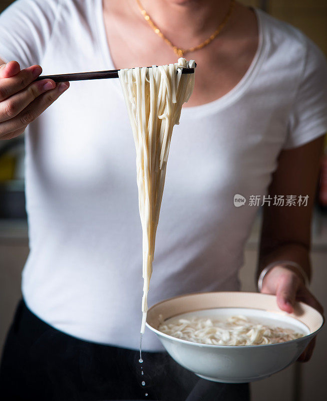 女人在家里煮面条