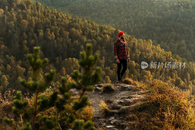 山里的旅行者。一个男人欣赏着美丽的山景。山中日出的人。一个男人在高加索旅行。山中日落时的徒步旅行者。本空间