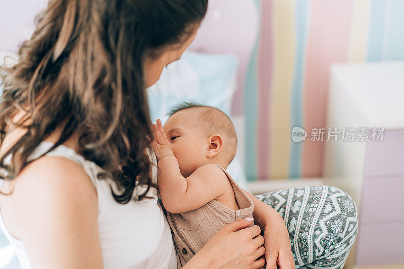年轻的母亲正在给婴儿喂奶。体外受精(IVF)。家庭的亚洲人