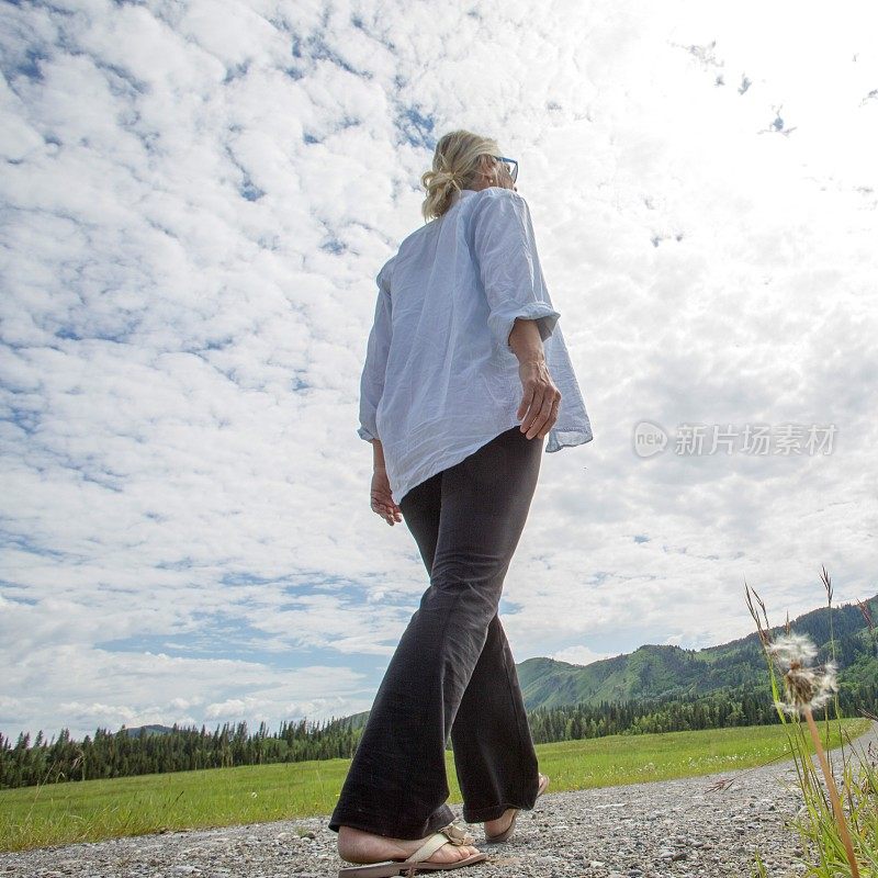 清晨，女人走过小径，穿过草地