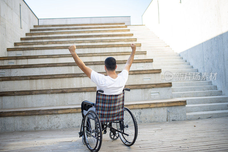 石阶和坐轮椅的年轻人做胜利的手势