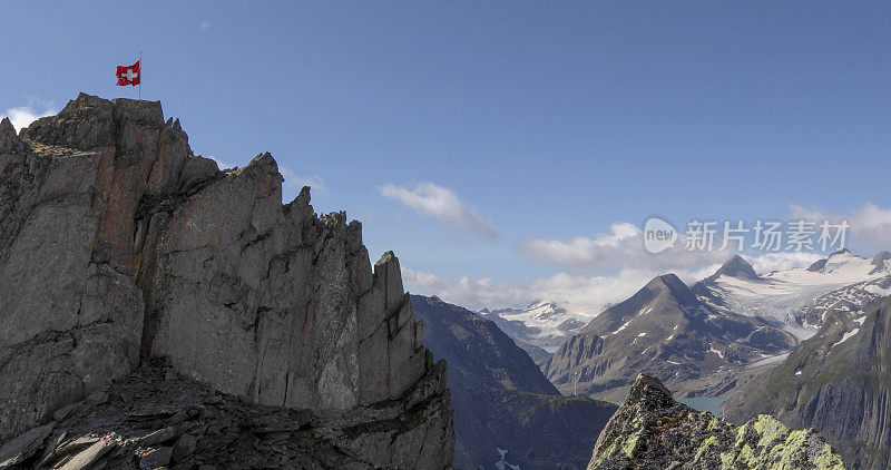 瑞士国旗在多岩石的山顶上迎风飘扬