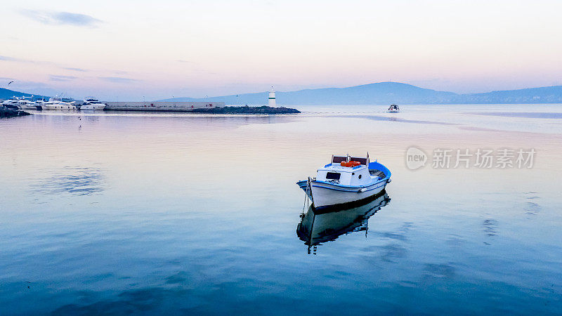 土耳其艾瓦利克，一艘孤独的小船漂浮在宁静的海面上