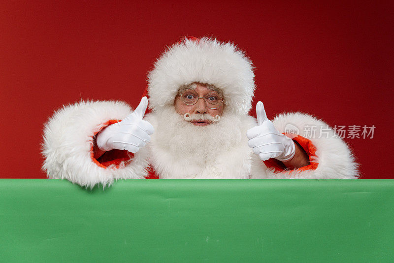 圣诞老人在明亮的红色背景上，大拇指在色度键上方