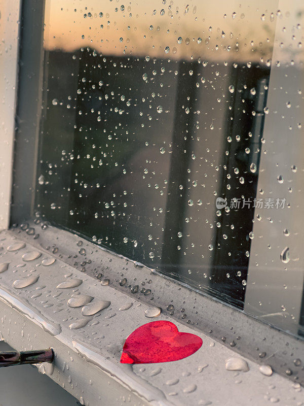被雨水淋湿的窗框上贴着红心贴纸