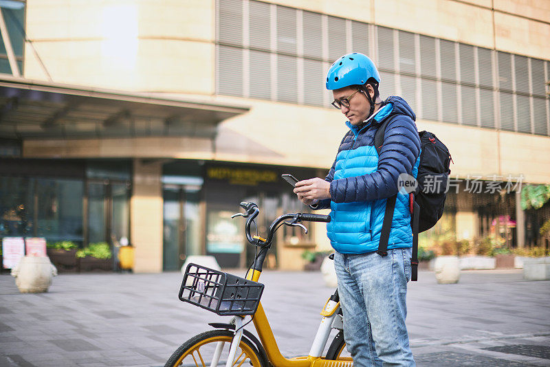 中年男性上班族使用手机扫描和共享自行车