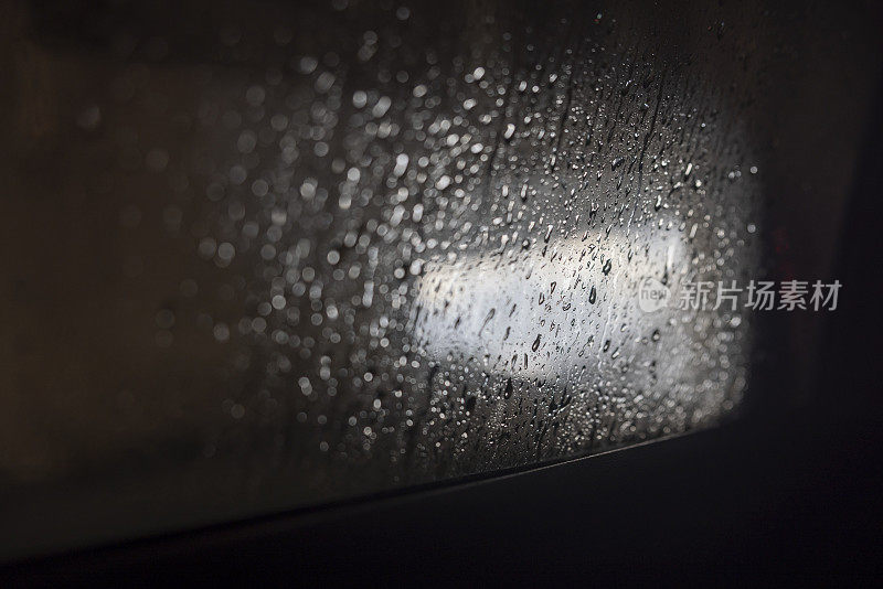 酒后驾车下雨。水滴在后视镜上。
