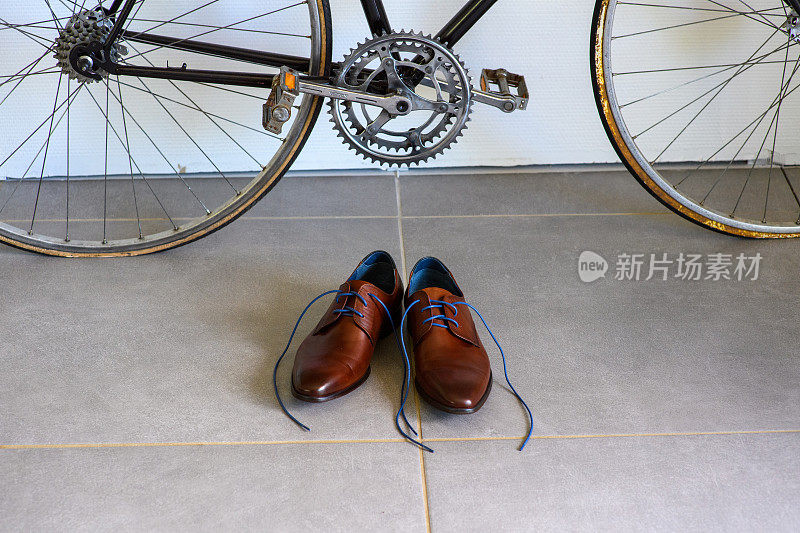 男士正装鞋放在自行车前的瓷砖地板上