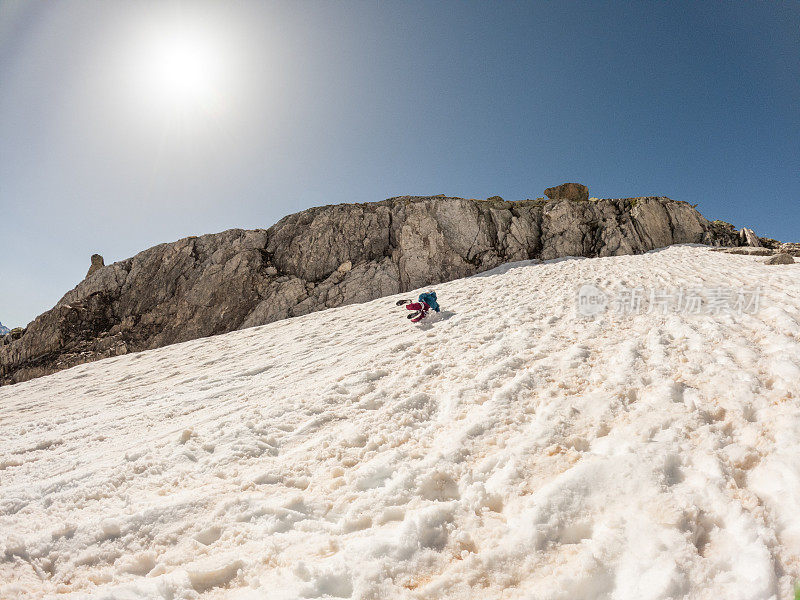 在冰川上练习摔倒的登山运动员