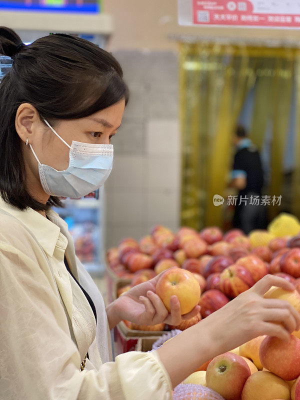 一位中年妇女正在摘苹果