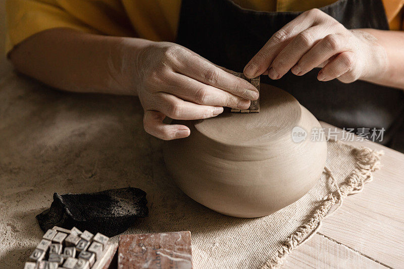 陶工制作陶罐的双手，特写照片