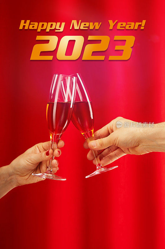 2023年新年快乐。一对新人在红帘子前拿着香槟庆祝，庆祝和享受这一刻