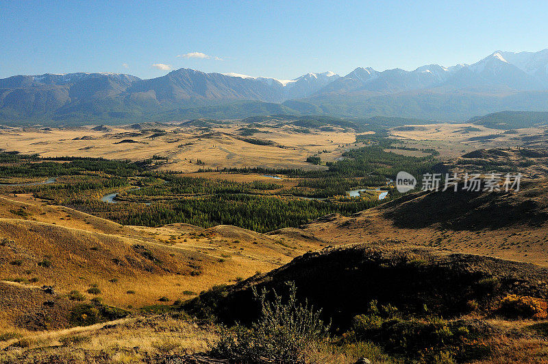 从山顶可以看到雪山脚下的秋谷和蜿蜒的美丽河流河床。