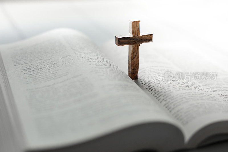 木制十字架立在打开的圣经上
