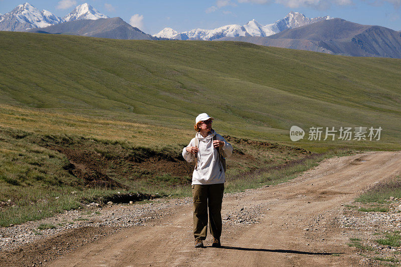 一位成熟的女背包客走在山路上