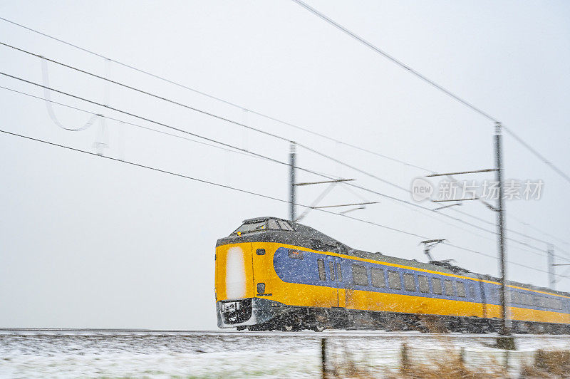 荷兰铁路公司的城际列车行驶在雪地上