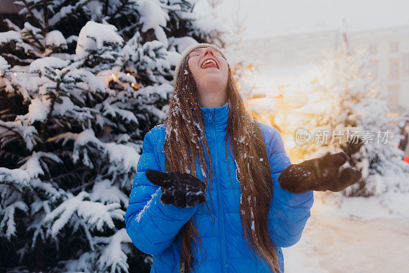 快乐的女人背着背包，在克拉科夫思考下雪的圣诞节