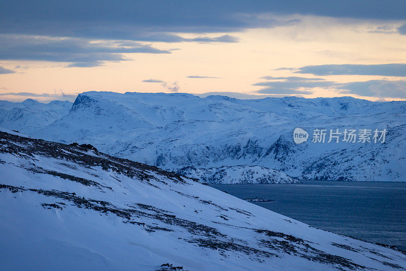 日落时挪威峡湾的冬季景观。