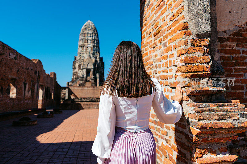 在泰国大城府历史公园的Ratchaburana寺，一位年轻女子的后景