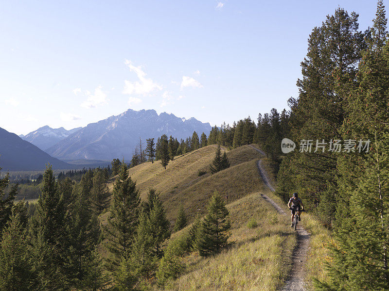 男性骑自行车的人沿着山路