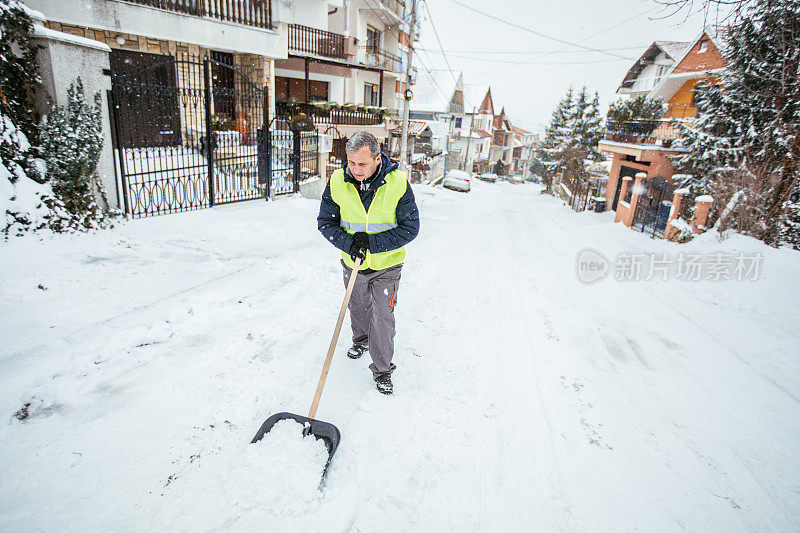 一名男子正在清理门口的积雪