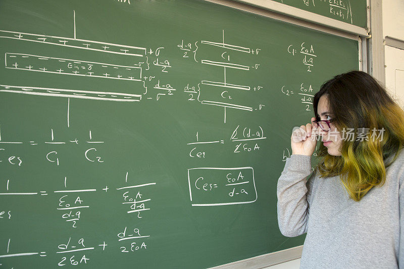 女同学在黑板前写公式
