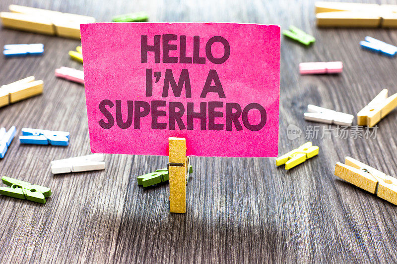 写一张便条，上面写着“你好，我是超级英雄”。商业照片展示相信自己自信介绍多剪辑木桌小卡片剪通知公告。