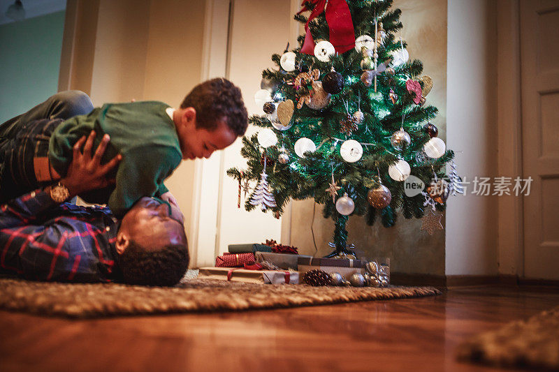 爸爸和儿子在圣诞树旁玩