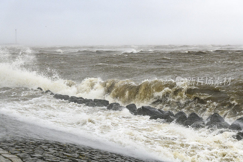 暴风雨中海浪冲击着IJsselmeer的堤坝