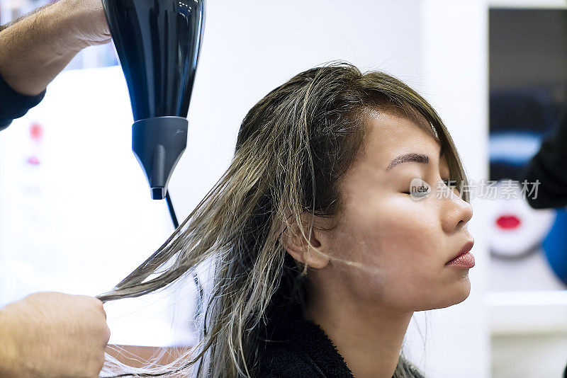 在美容院理发的亚洲妇女